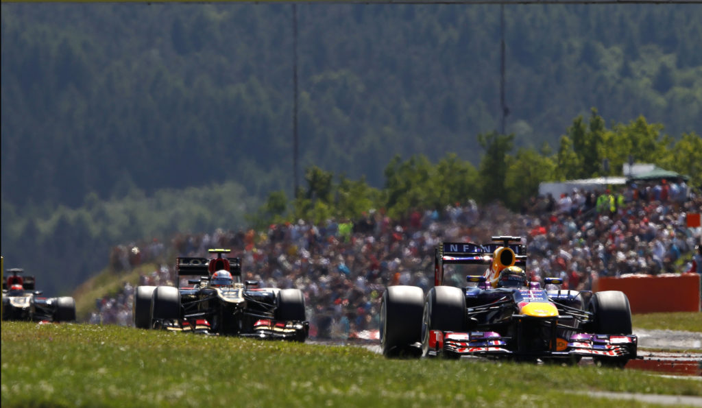 Red Bull driver Sebastian Vettel leads Romain Grosjean of Lotus en route to win 2013 F1 German GP