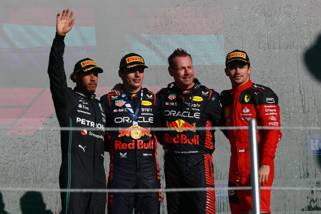 Red Bull driver Max Verstappen celebrates on 2023 F1 Abu Dhabi GP podium with Lewis Hamilton of Mercedes and Charles Leclerc of Ferrari
