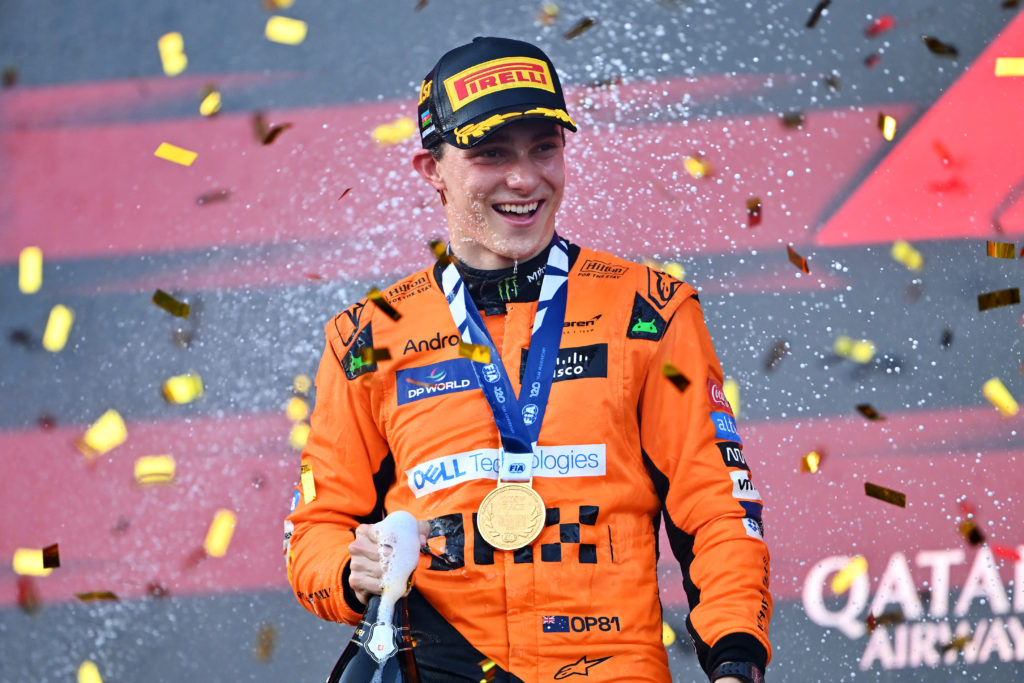 Oscar Piastri smiles with a medal around his neck during the champagne spray for winning the Azerbaijan Grand Prix
