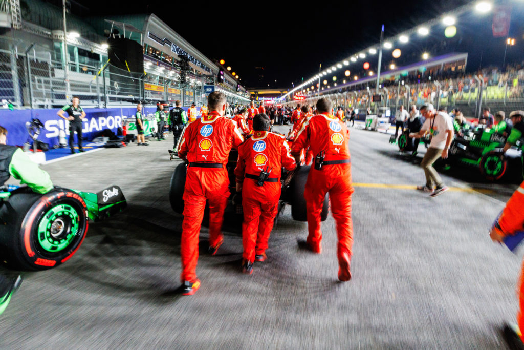 Scuderia Ferrari mechanics push the car of Charles Leclerc