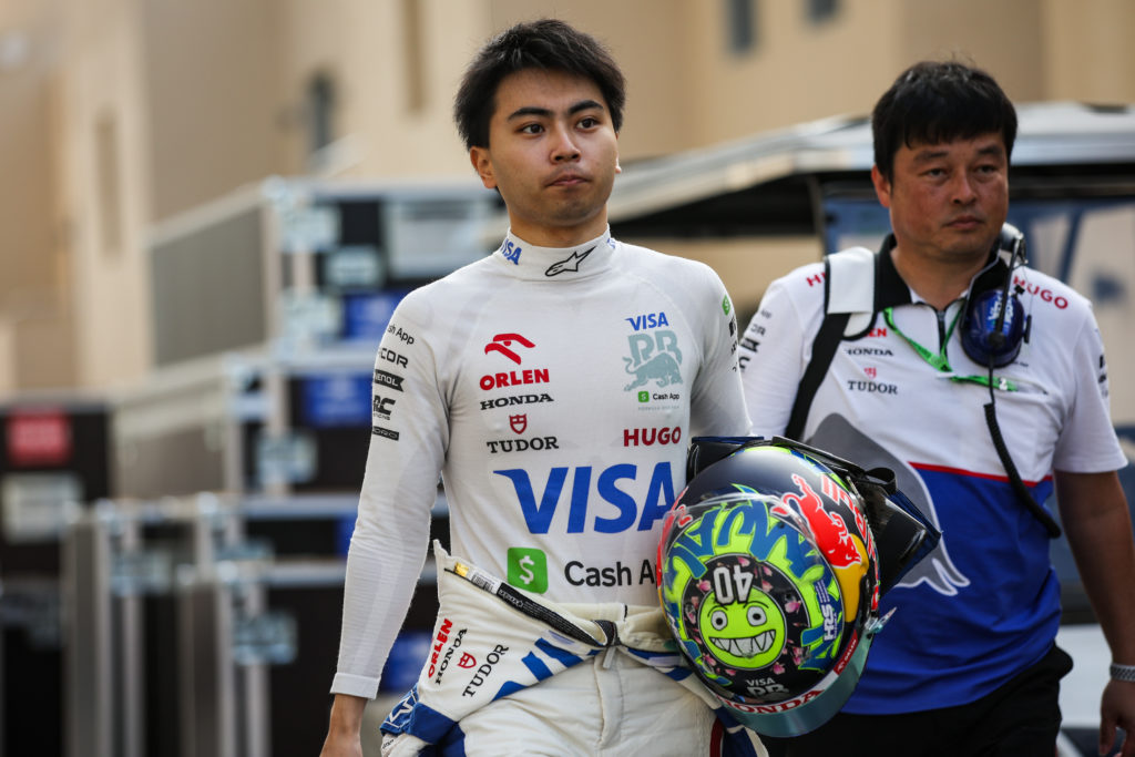 Ayumu Iwasa walks through the paddock carrying his helmet ahead of F1 testing at the Yas Marina Circuit
