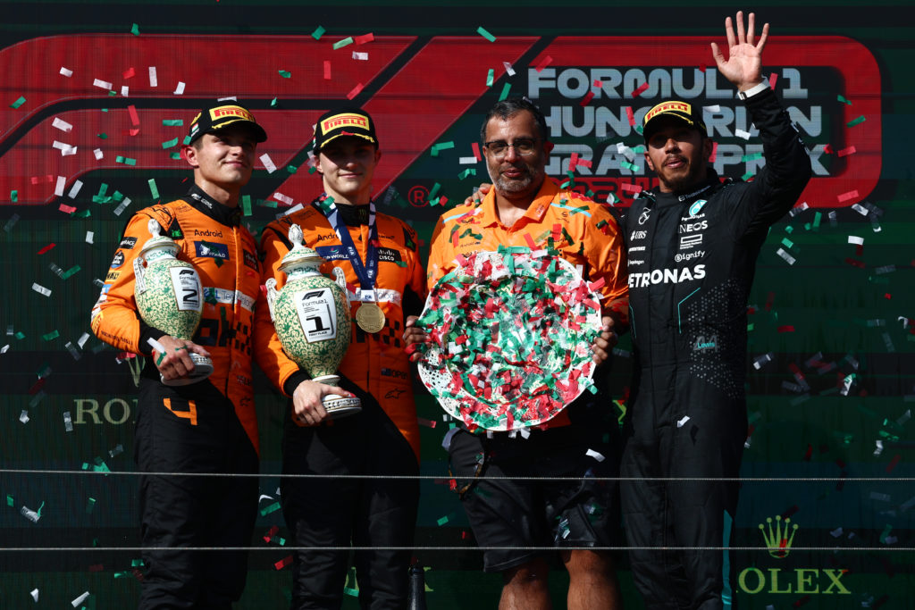 McLaren driver Oscar Piastri celebrates his first F1 race win on the 2024 Hungarian Grand Prix podium with Lando Norris and Lewis Hamilton