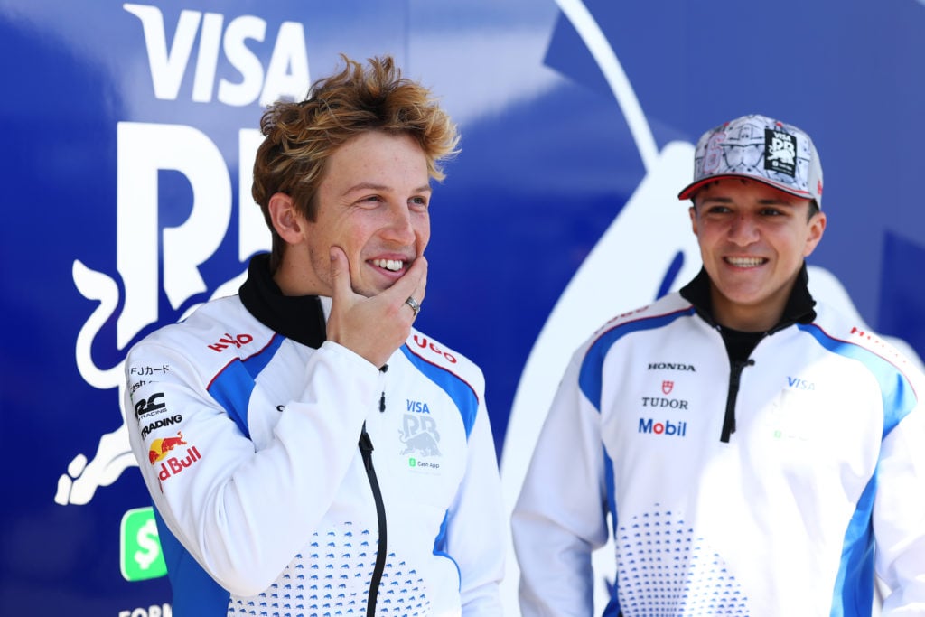 Isack Hadjar smiles at Liam Lawson at the 2025 Japanese Grand Prix
