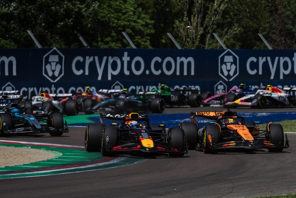 Red Bull driver Max Verstappen passes Oscar Piastri of McLaren to lead the 2025 F1 Emilia Romagna Grand Prix at Imola