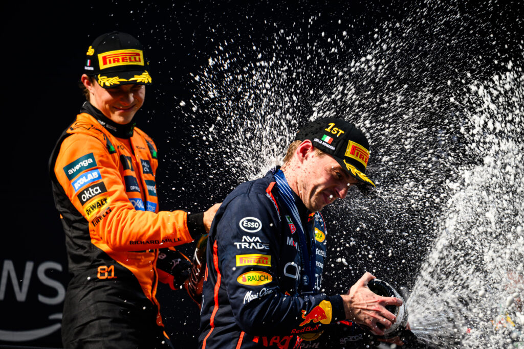 McLaren driver Oscar Piastri and Max Verstappen of Red Bull celebrate on the Imola podium after the 2025 F1 Emilia Romagna Grand Prix