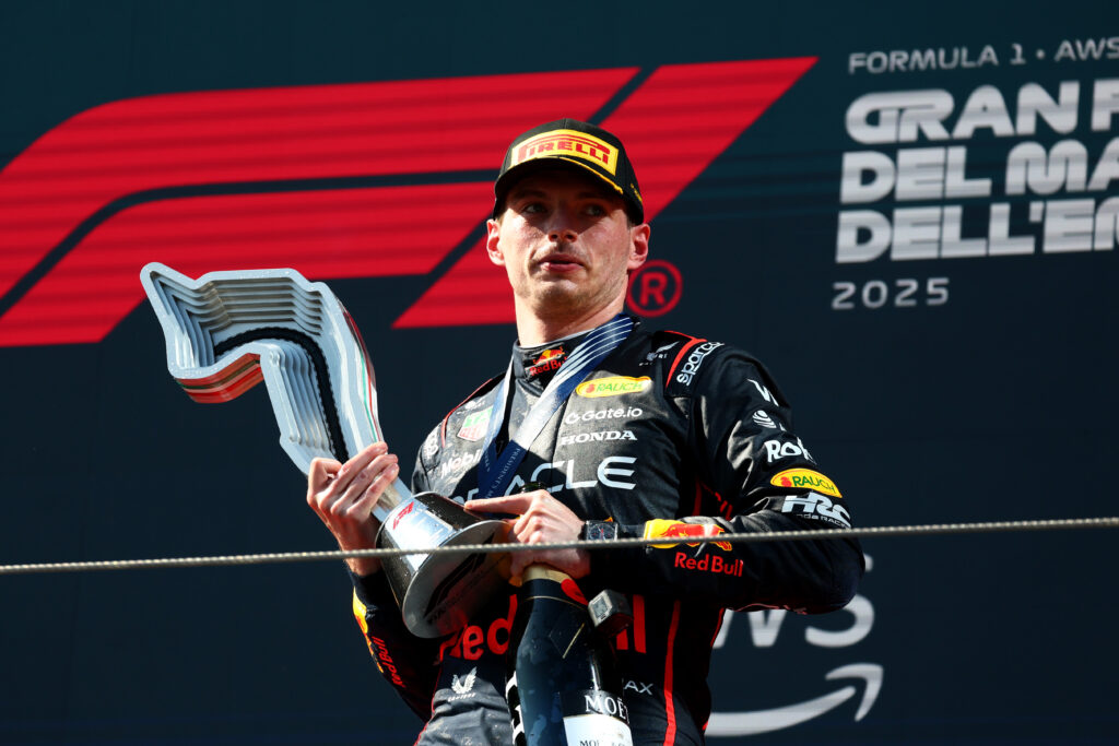 Red Bull Racing driver Max Verstappen standing on the podium with his trophy at the 2025 Emilia Romagna Grand Prix