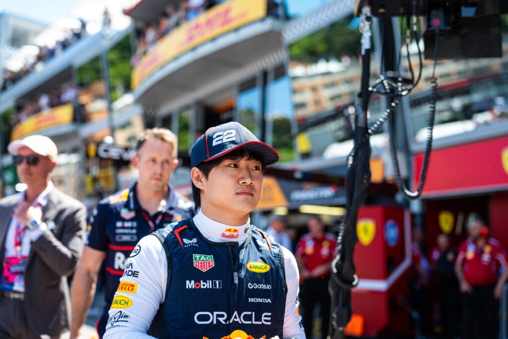 Red Bull Racing driver Yuki Tsunoda walking through the pit lane at the 2025 Monaco Grand Prix