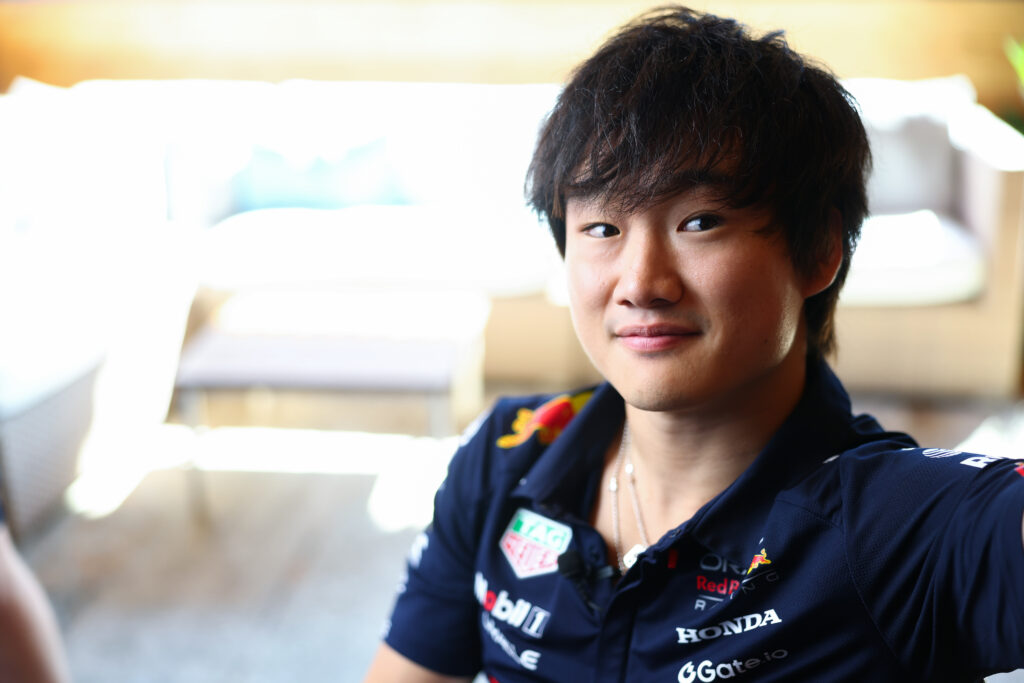 Yuki Tsunoda smiles in the Red Bull hospitality