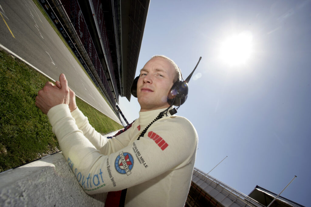 Former GP2 driver Alexandre Premat leans over the pit wall
