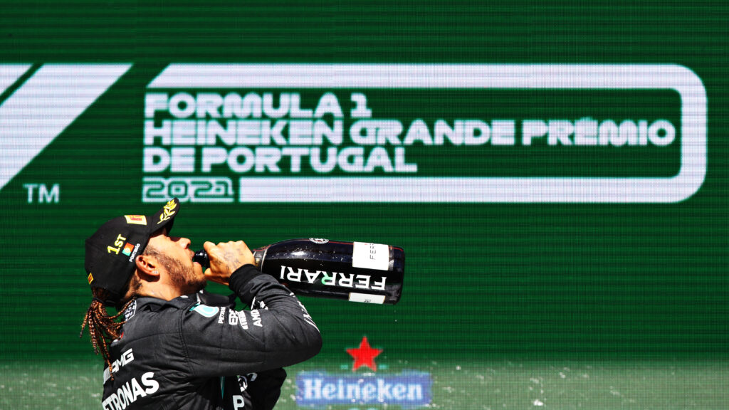 Lewis Hamilton dips champagne on the podium at the Portuguese Grand Prix