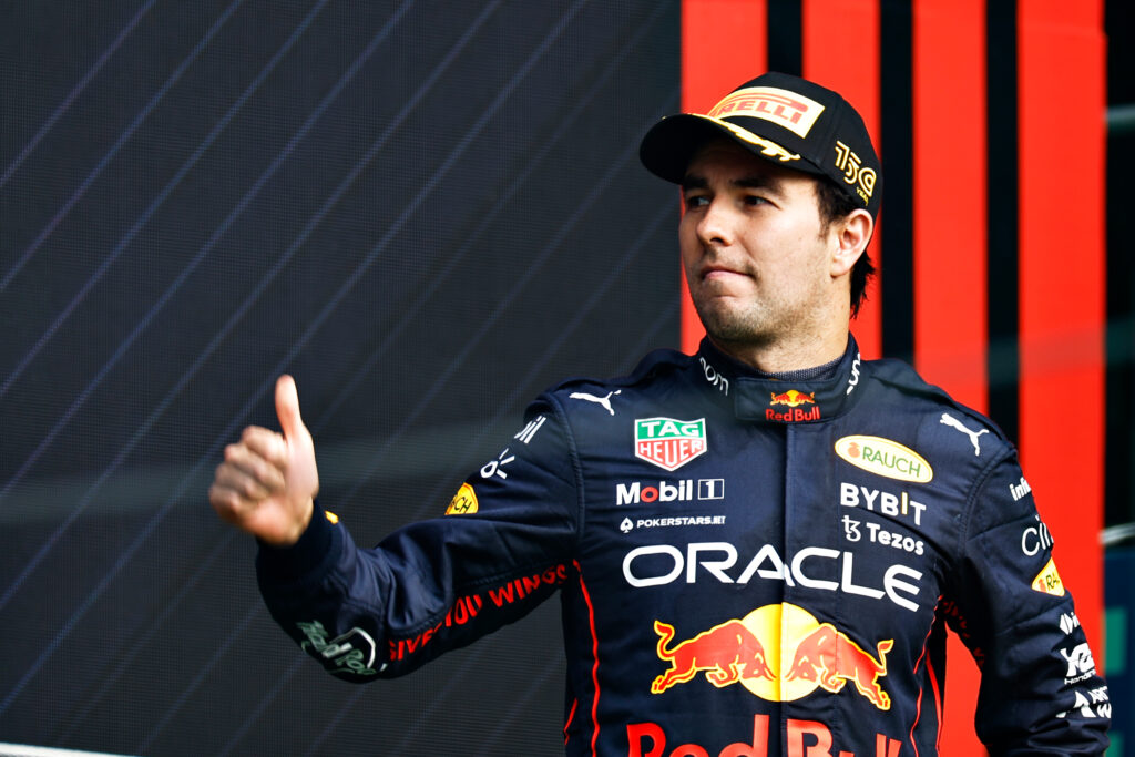 Sergio Perez gives a thumb on the podium in Red Bull colours