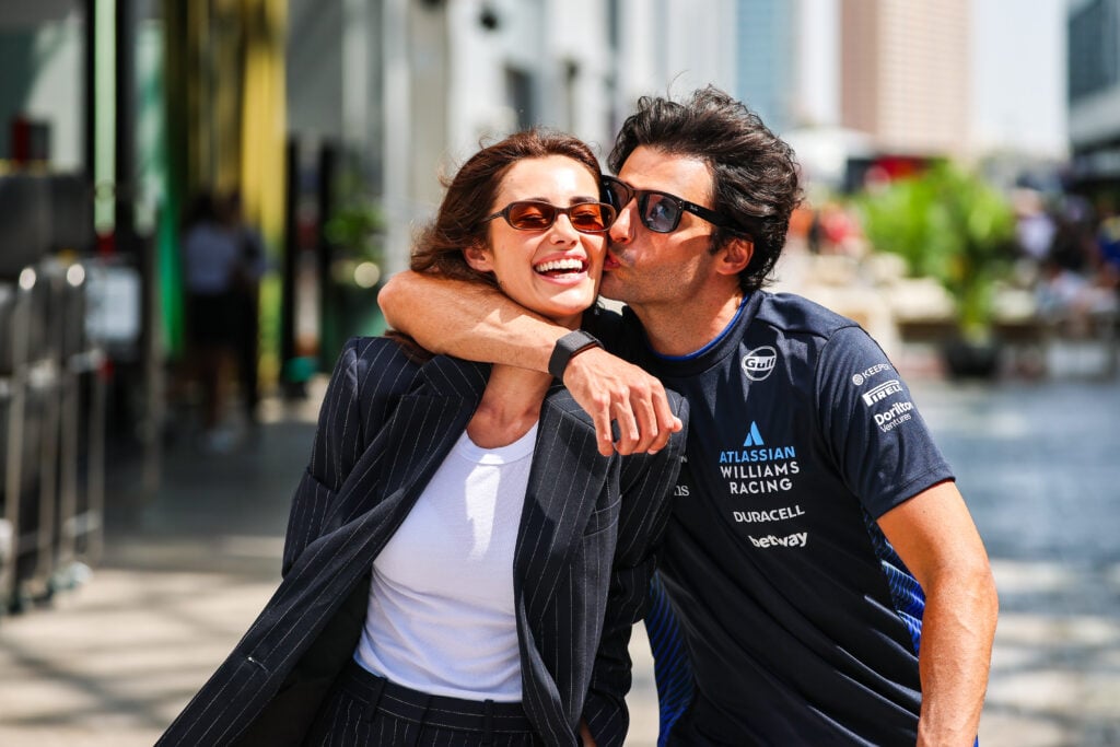 Carlos Sainz kisses the cheek of girlfriend Rebecca Donaldson as she laughs at the Saudi Arabian Grand Prix