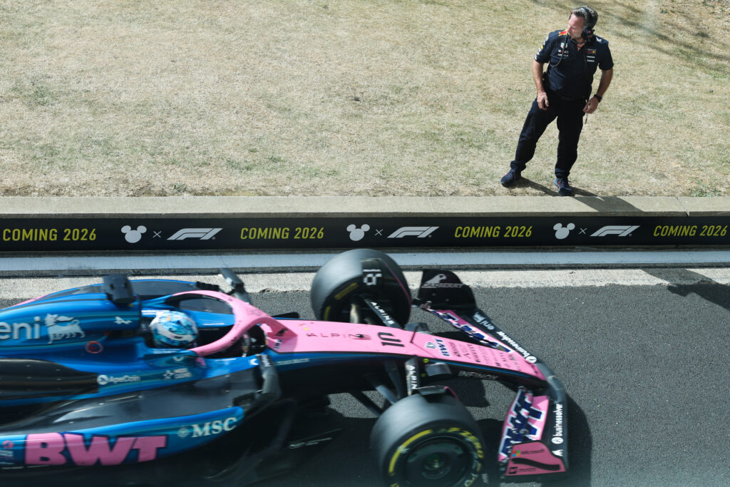 Christian Horner watches on as Pierre Gasly of Alpine drives in the F1 pit lane