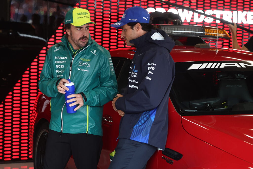 Aston Martin driver Fernando Alonso with Williams' Alex Albon in the 2025 F1 British Grand Prix paddock