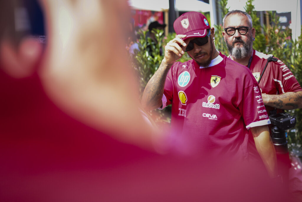 Lewis Hamilton of Ferrari walks through the F1 paddock