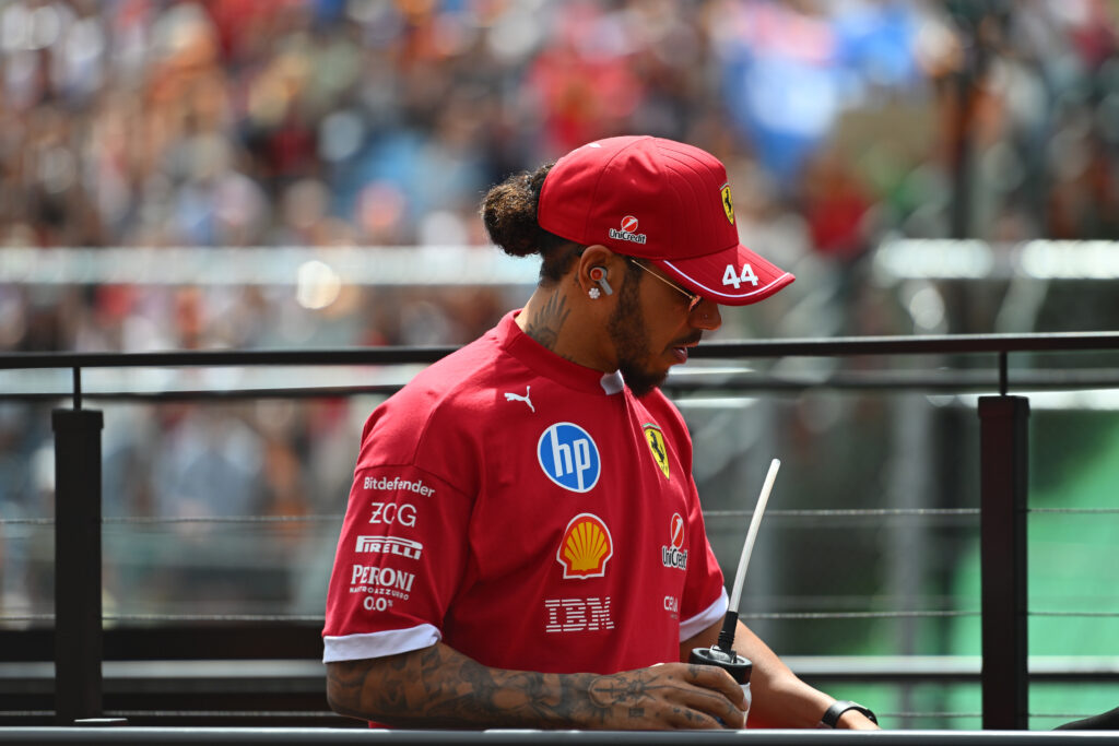 Lewis Hamilton of Ferrari stands on the drivers' parade truck