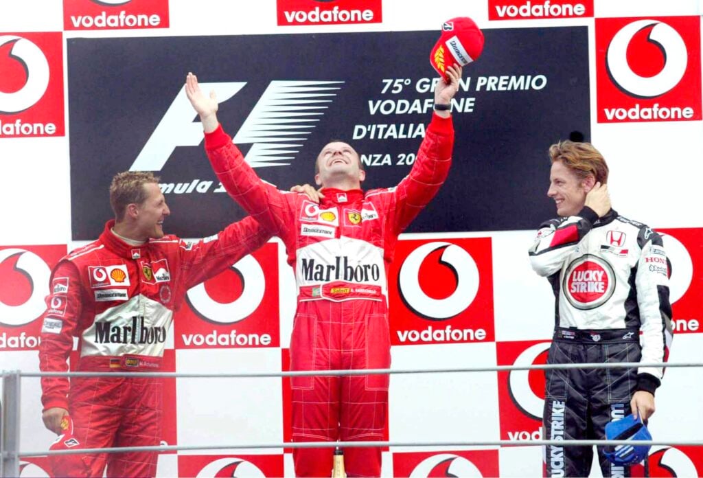 Ferrari drivers Rubens Barrichello and Michael Schumacher and BAR driver Jenson Button on the podium at the 2004 Italian Grand Prix