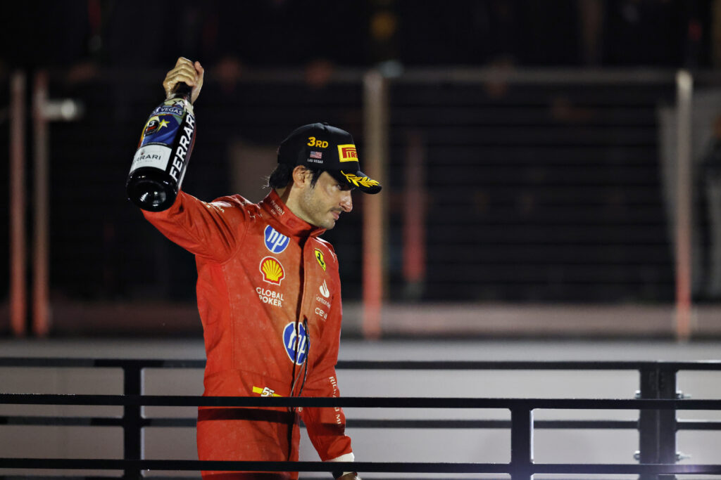 Carlos Sainz holds a bottle of champagne after finishing on the Las Vegas Grand Prix podium for Ferrari