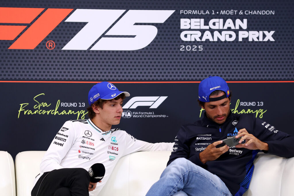 Mercedes driver Andrea Kimi Antonelli (left) watching Williams driver Carlos Sainz's (right) phone during a press conference at the 2025 Formula 1 Belgian Grand Prix