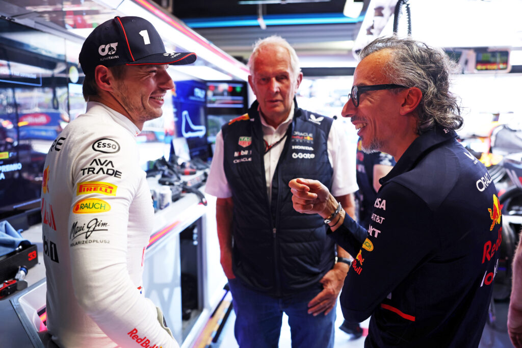 Red Bull driver Max Verstappen (left) grinning while in conversation with Red Bull chief advisor Helmut Marko (centre) and Red Bull team principal Laurent Mekies (right) at the 2025 Formula 1 Italian Grand Prix