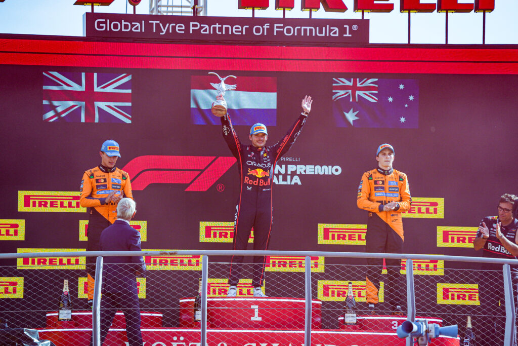 Red Bull driver Max Verstappen celebrating on the top step of the podium alongside McLaren drivers Lando Norris and Oscar Piastri at the 2025 Formula 1 Italian Grand Prix
