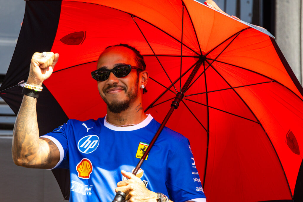 Ferrari driver Lewis Hamilton raising his fist and holding an umbrella at the 2025 Formula 1 Italian Grand Prix