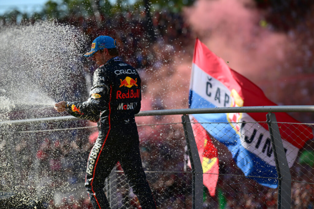 Red Bull Racing driver Max Verstappen spraying champagne in front of Ferrari's fans on the podium at the 2025 Formula 1 Italian Grand Prix