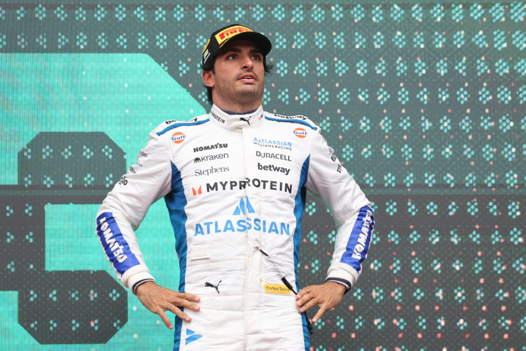 Williams driver Carlos Sainz standing on the podium with his hands on his hips at the 2025 Formula 1 Azerbaijan Grand Prix