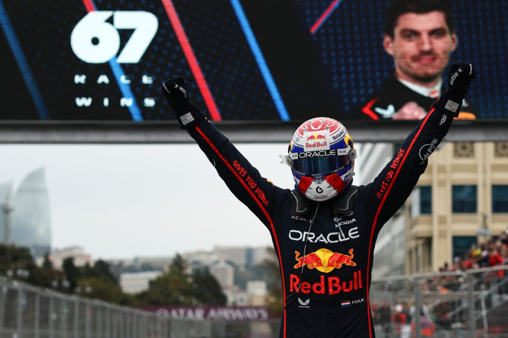 Red Bull Racing driver Max Verstappen standing with his arms aloft after winning the 2025 Formula 1 Azerbaijan Grand Prix