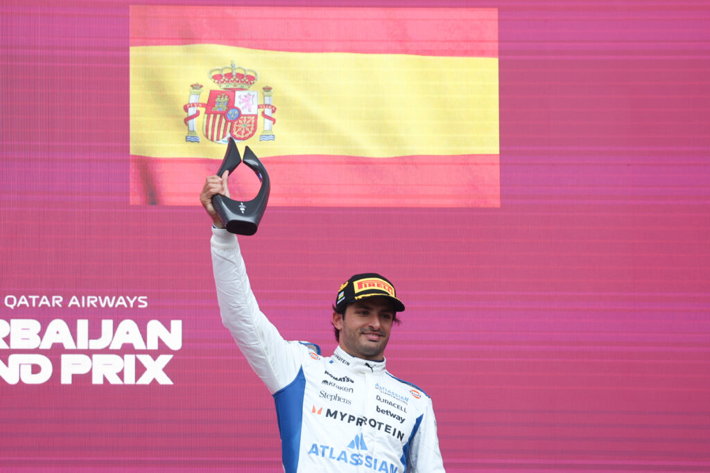 Williams driver Carlos Sainz lifting a trophy aloft after finishing on the podium at the 2025 Formula 1 Azerbaijan Grand Prix