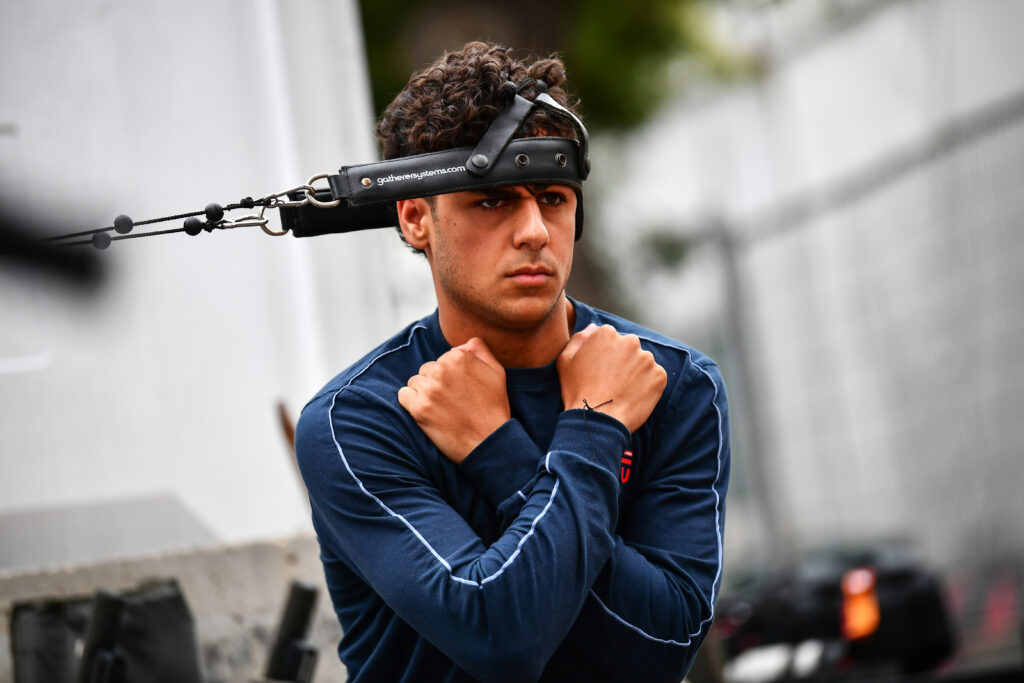 Red Bull academy driver Arvid Lindblad warms up his neck before a Formula 2 race