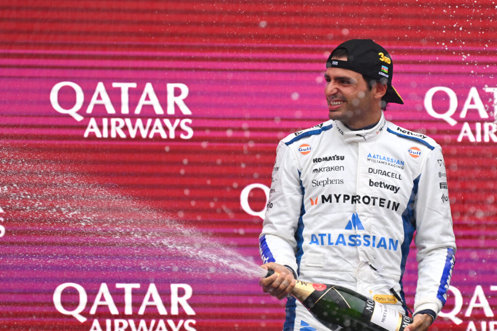 Williams driver Carlos Sainz spraying champagne on the podium at the 2025 Formula 1 Azerbaijan Grand Prix