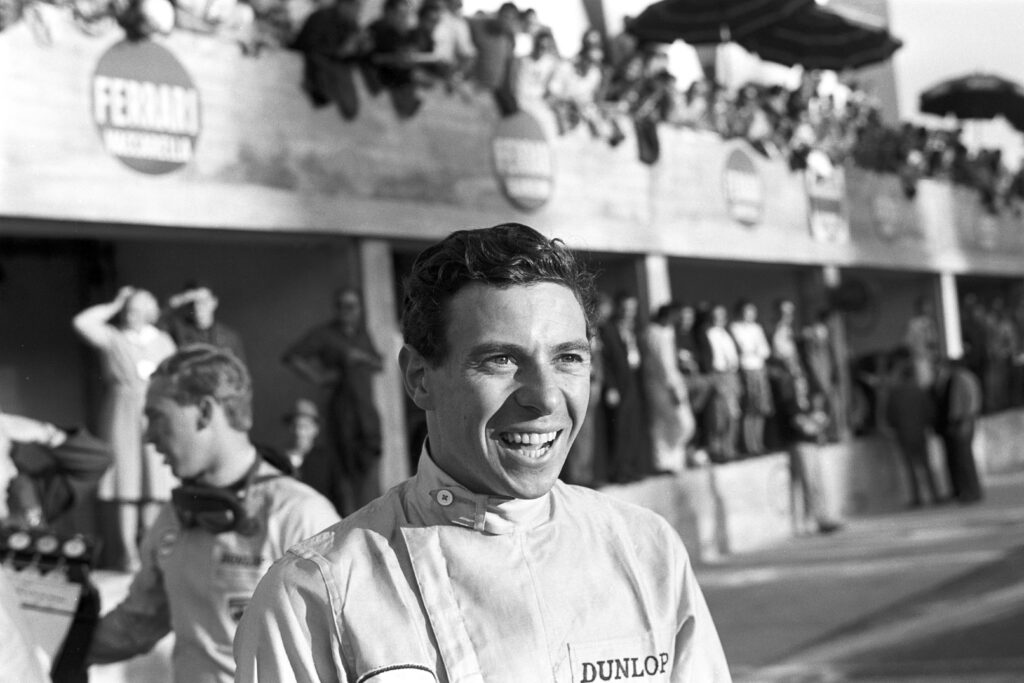 Jim Clark smiling in the pit lane at the 1965 Italian Grand Prix.