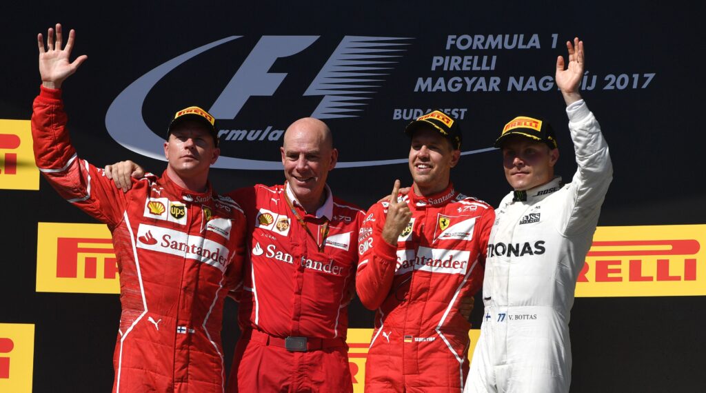 Ferrari drivers Kimi Raikkonen and Sebastian Vettel on the podium with Ferrari engineer Jock Clear and Mercedes driver Valtteri Bottas at the 2017 Formula 1 Hungarian Grand Prix