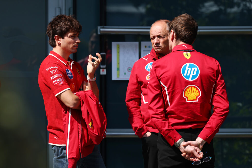 Ferrari driver Charles Leclerc speaks with team principal Fred Vasseur in the 2025 F1 Singapore Grand Prix paddock