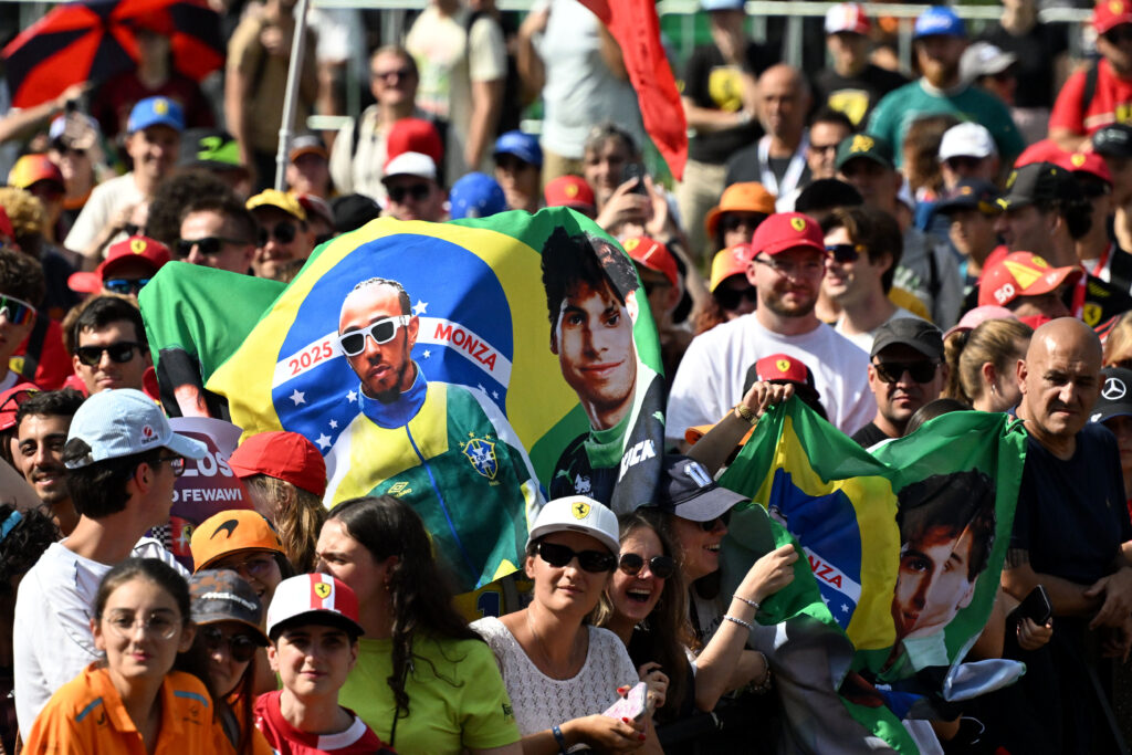 Fans at the 2025 Formula 1 Italian Grand Prix holding a Brazilian flag pictured with Ferrari driver Lewis Hamilton and Sauber driver Gabriel Bortoleto