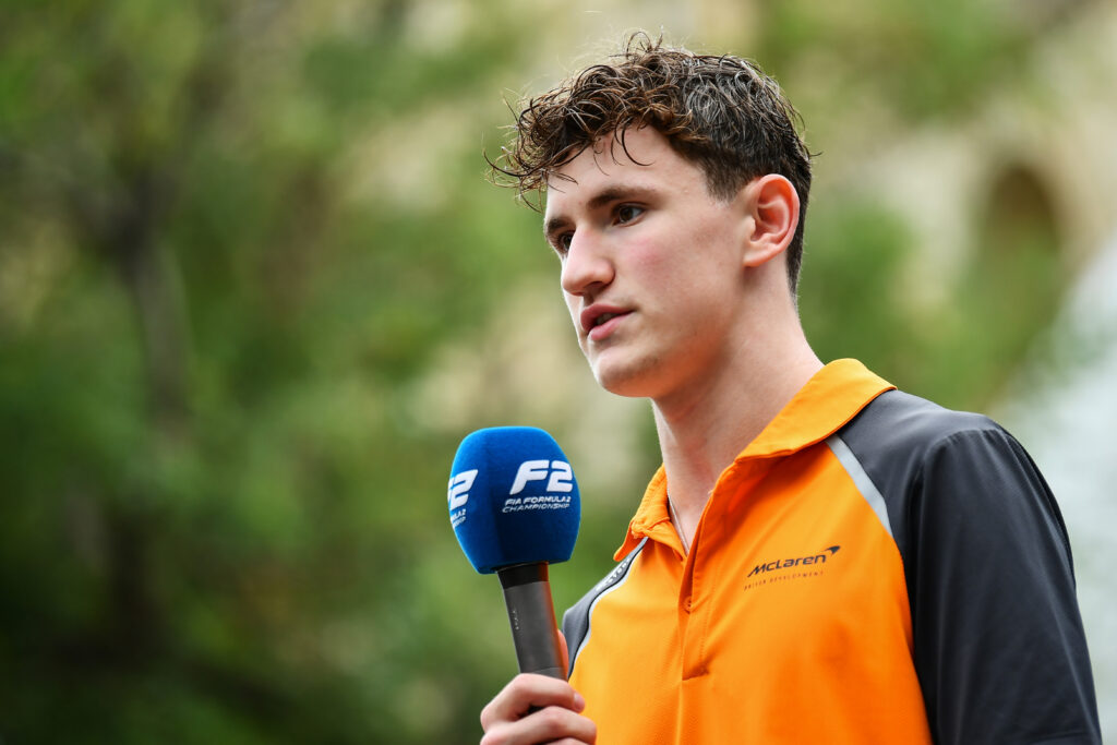 Alex Dunne speaks in a Formula 2 interview in McLaren gear