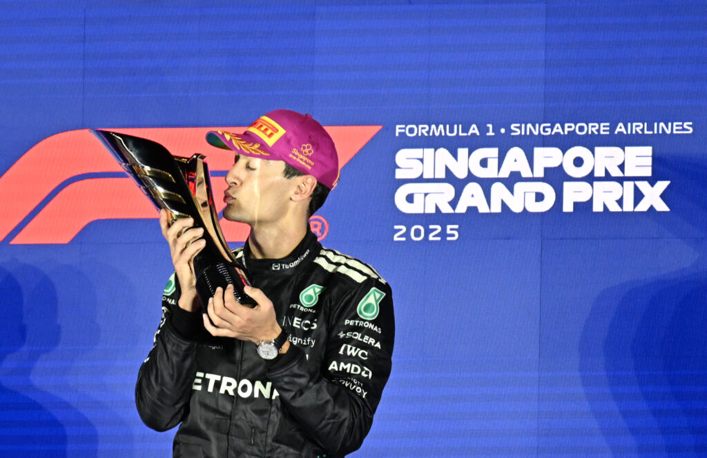 Mercedes driver George Russell kisses his trophy after winning the 2025 F1 Singapore Grand Prix