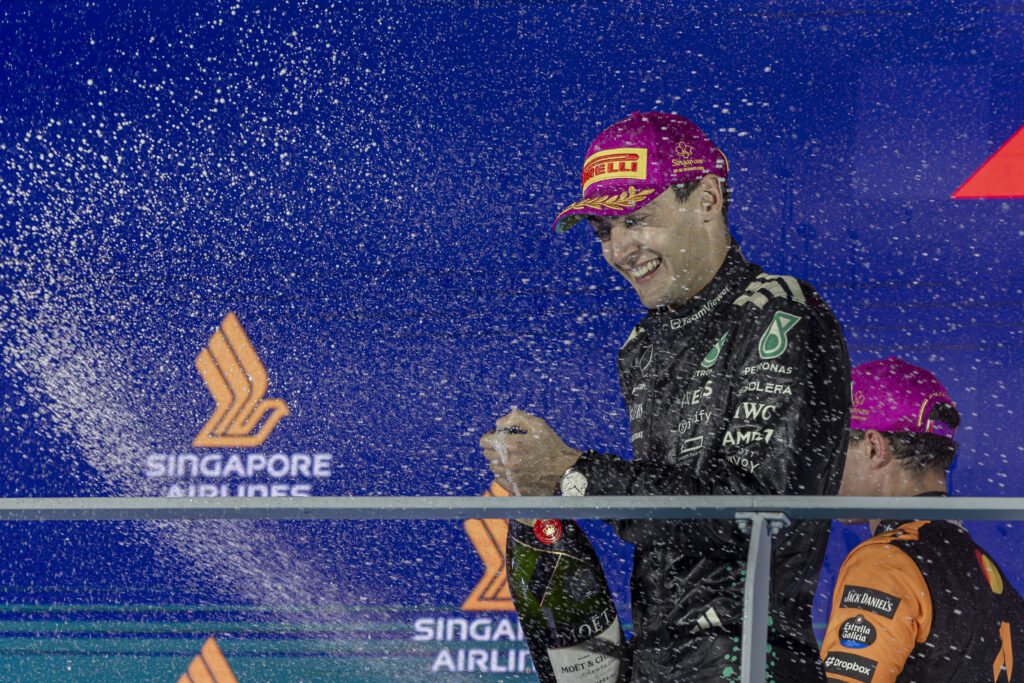 Mercedes driver George Russell spraying champagne on the podium at the 2025 Formula 1 Singapore Grand Prix