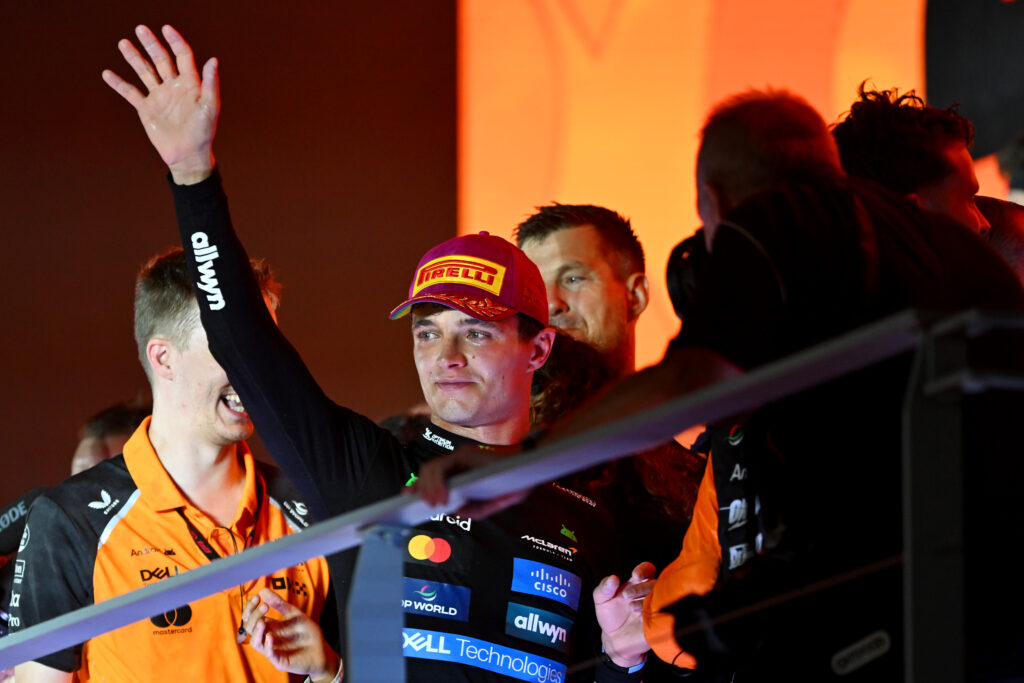 McLaren driver Lando Norris waving to the crowd at the 2025 Formula 1 Singapore Grand Prix