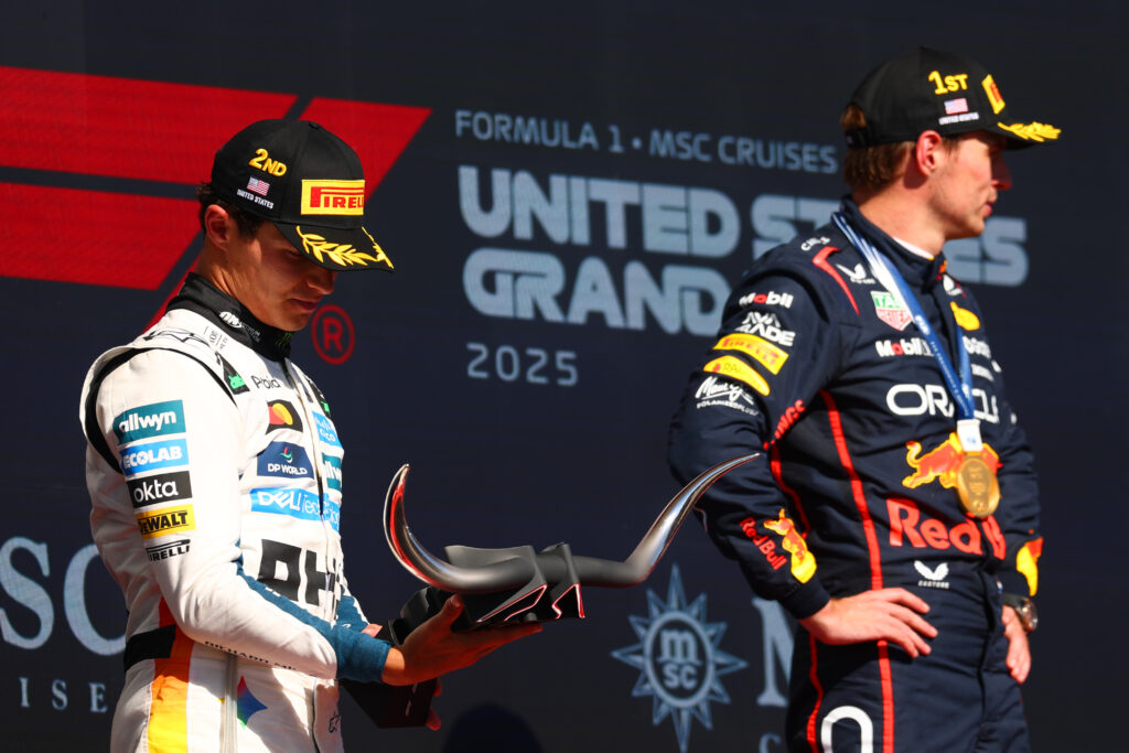 McLaren's Lando Norris looks at his P2 trophy on the 2025 F1 United States Grand Prix podium next to Red Bull's Max Verstappen