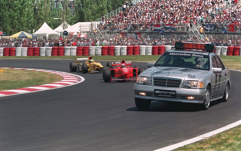 The Mercedes-Benz safety car leads Michael Schumacher's Ferrari and Giancarlo Fisichella's Jordan at the Canadian Grand Prix in front of fans