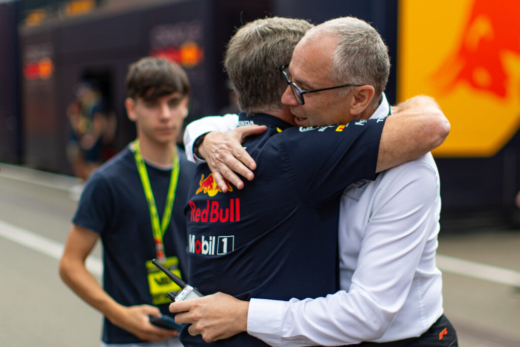 F1 CEO Stefano Domenicali embraces Christian Horner in the Red Bull Ring paddock ahead of practice at the 2025 F1 Austrian Grand Prix