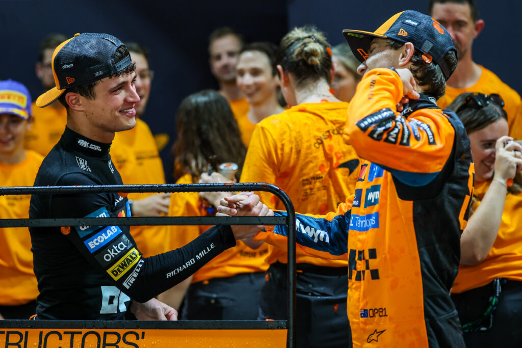 McLaren drivers Lando Norris and Oscar Piastri shaking hands after the 2025 Formula 1 Singapore Grand Prix