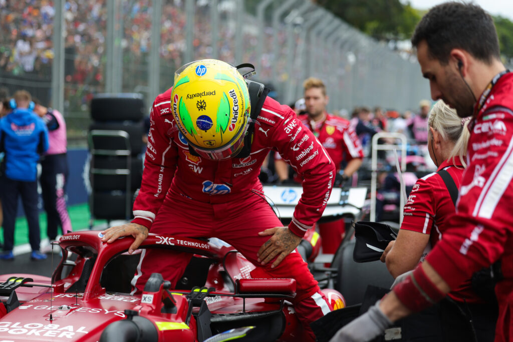 Lewis Hamilton climbing out of his Ferrari F1 car during a red flag period in the Brazilian Grand Prix Sprint.