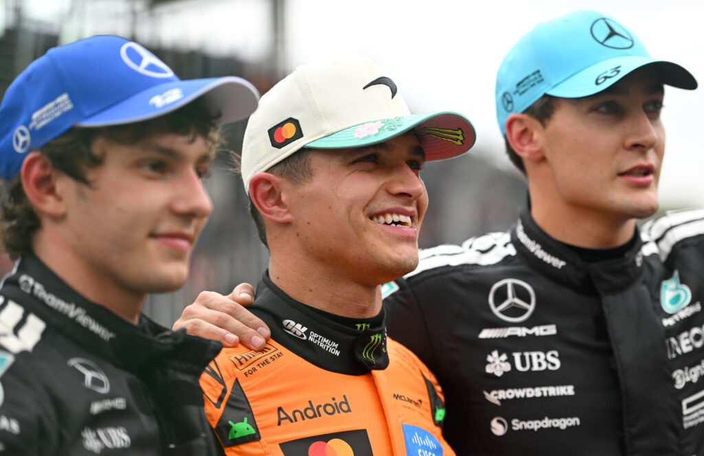Lando Norris smiles in the middle of Kimi Antonelli and George Russell following his win in the Brazilian Grand Prix Sprint race.