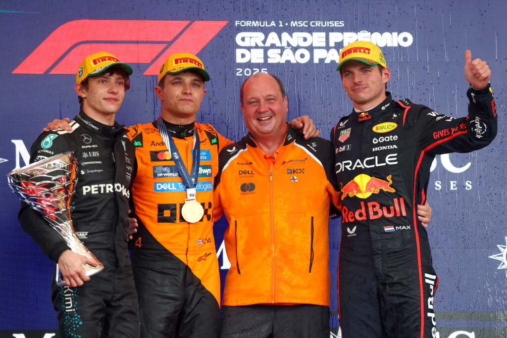 Race winner Lando Norris of McLaren, Second placed Andrea Kimi Antonelli of Mercedes and third placed Max Verstappen of Red Bull Racing and Mark Norris, Director of Commercial Trackside Operations at McLaren on the podium during the 2025 Sao Paulo Grand Prix