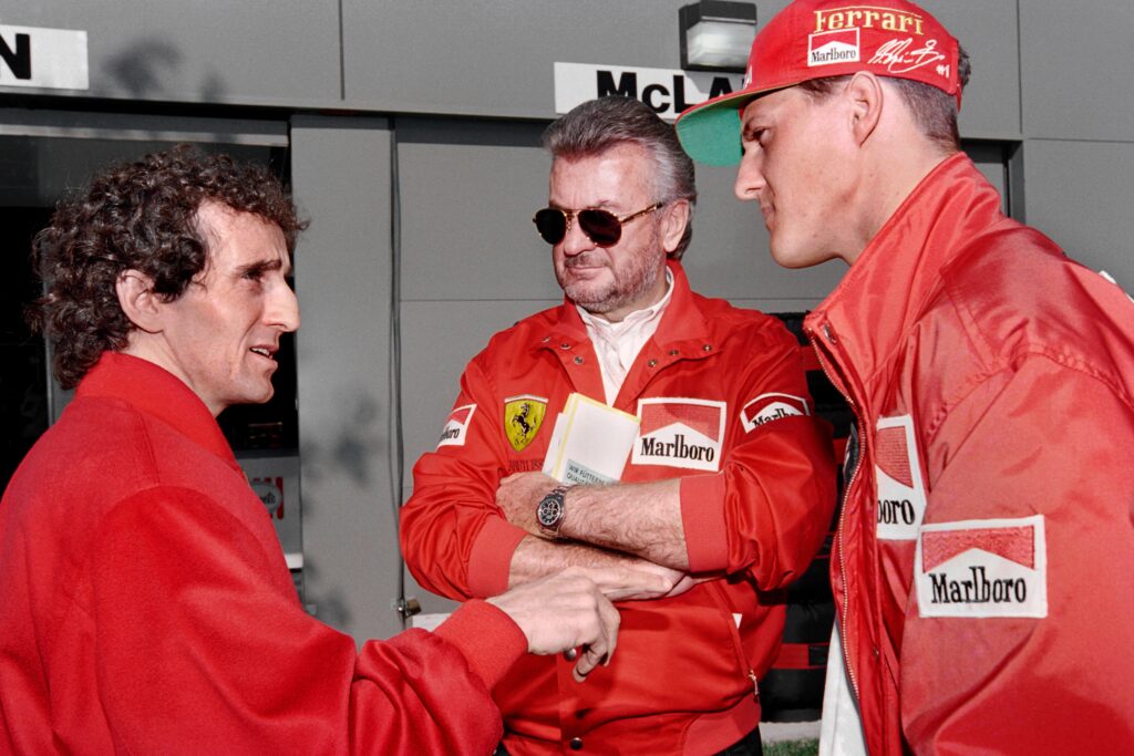 Michael Schumacher talking to Alain Prost at the 1996 Australian Grand Prix, with agent Willi Weber between them.