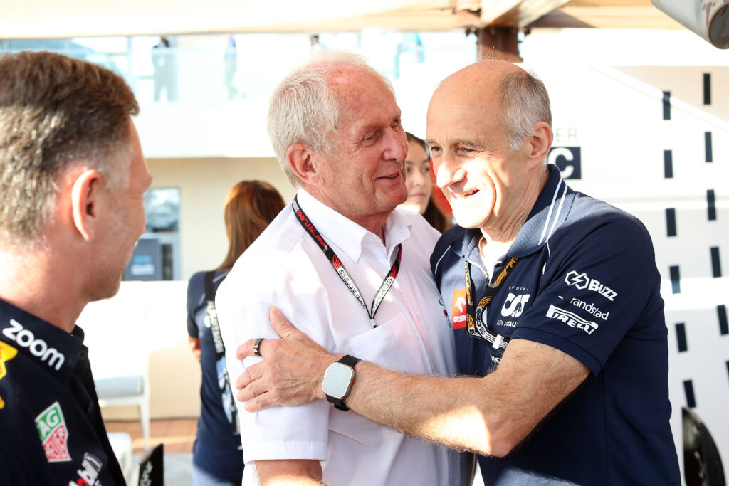 Franz Tost laughing and hugging Helmut Marko in the F1 paddock at the 2023 Abu Dhabi Grand Prix.