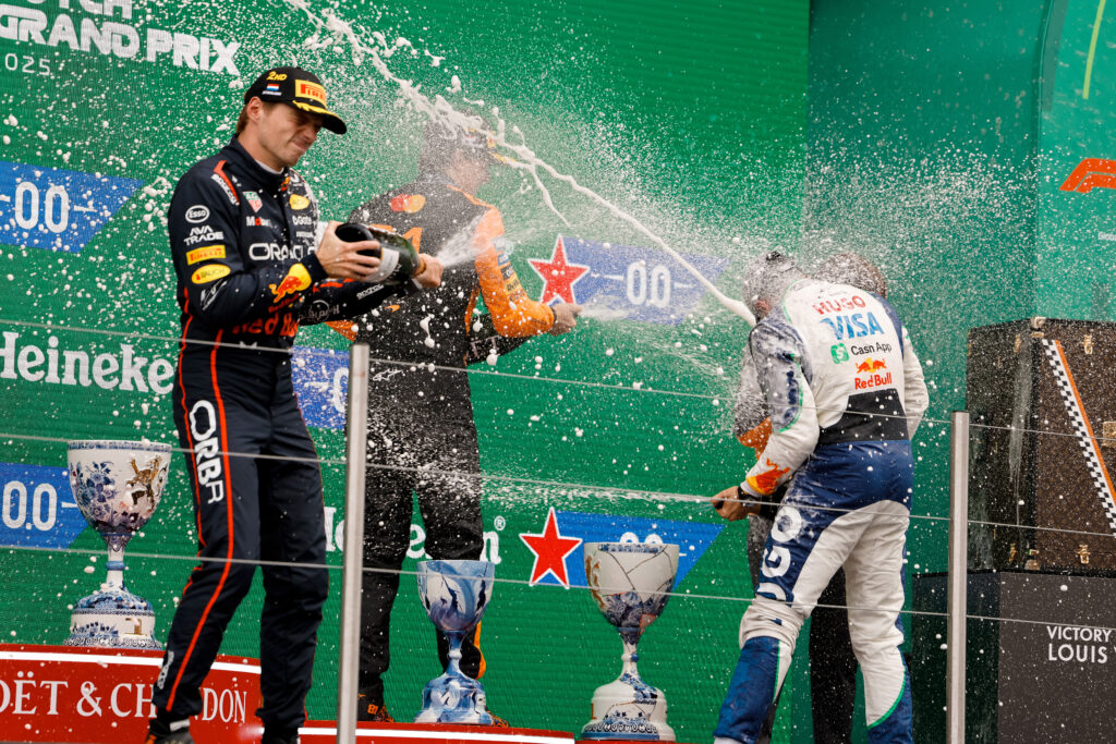 Max Verstappen and Isack Hadjar celebrating on the podium at the 2025 Formula 1 Dutch Grand Prix